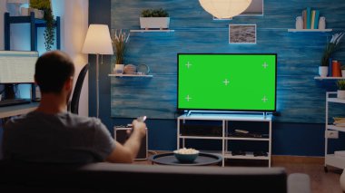 Yeşil ekran ekranlı bir adam televizyon izliyor