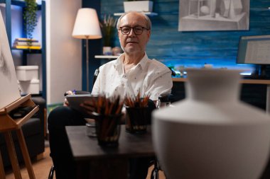 Engelli yaşlı sanatçı ilham için vazo tasarımı kullanıyor