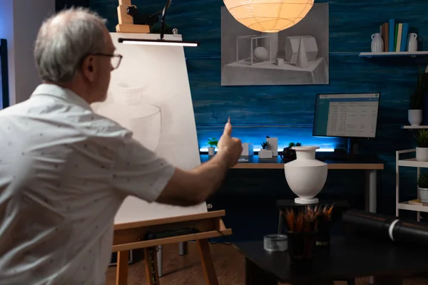 Старший художник использует вазу для рисования вдохновения на холсте — стоковое фото