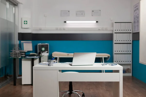 Пустой кабинет врачей с письменным столом и техникой — стоковое фото