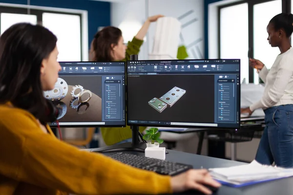 Engenheira industrial mulher trabalhando no PC com dois monitores, telas mostrando software CAD — Fotografia de Stock