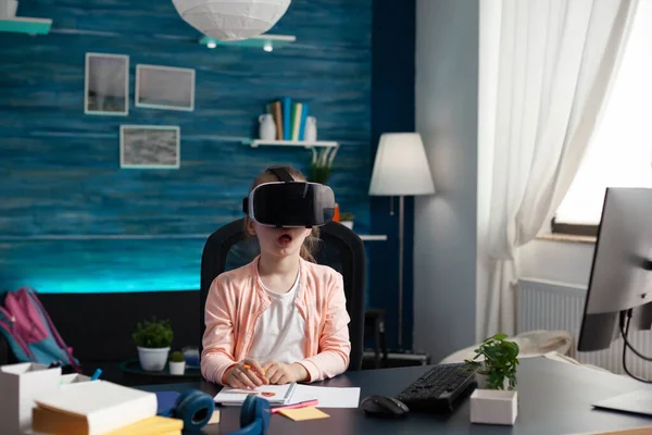 Little pupil at home desk using vr glasses for class — Stock Photo, Image