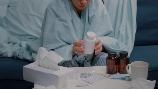 Mujer enferma con gripe sosteniendo frasco de pastillas y medicamentos — Vídeo de stock