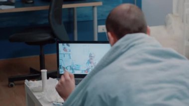 Videoda doktorla konuşan adam ellerinde kapsüllerle danışmanlık yapıyor.
