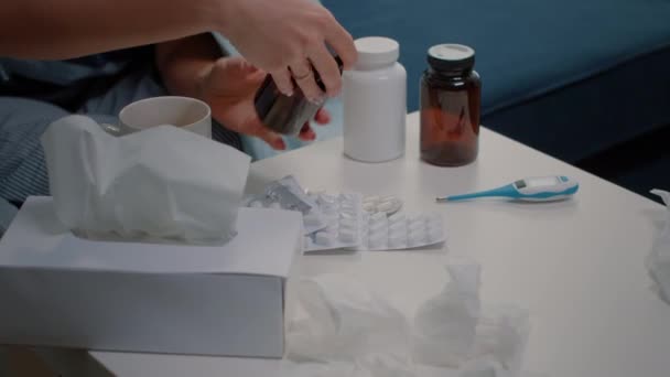 Zbliżenie kobiety ręka patrząc na butelkę i tabletki z pigułek — Wideo stockowe