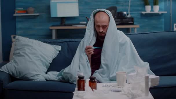 Homem malvado em temperatura de medição de cobertor com termômetro — Vídeo de Stock