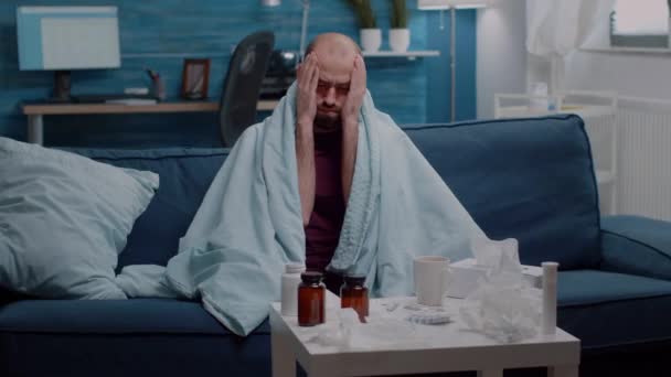 Kranker Mann mit Kopfschmerzen reibt Schläfen in Decke — Stockvideo