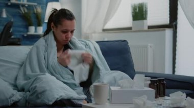 Hasta kadın soğuk burnu sümkürmek için doku kullanıyor.