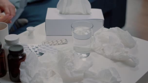 Detailní záběr šumivé pilulky ve sklenici vody na stole — Stock video