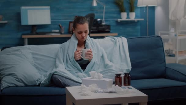 Porträt einer Frau mit Grippe, die eine Tasse Tee in der Decke hält — Stockvideo