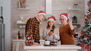 Torunu olan büyükannesi ve büyükbabası Noel Baba şapkası takıp çevrimiçi video görüşmesi sırasında uzak arkadaşlarını selamlıyorlar.