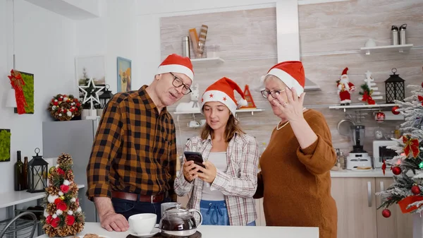 Happy rodina se Santa klobouk pozdrav vzdálených přátel během on-line videokall setkání pomocí telefonu — Stock fotografie