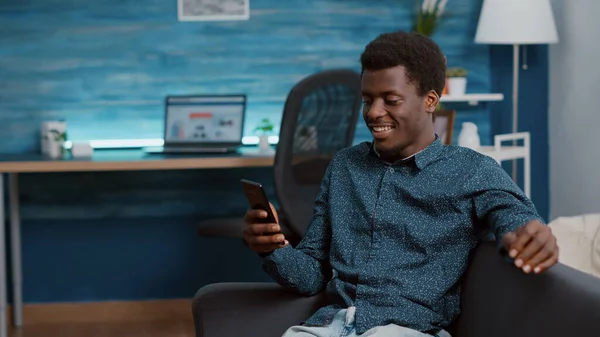 Hombre afroamericano auténtico en videollamada de comunicación virtual usando su teléfono para hablar con familiares o compañeros de trabajo —  Fotos de Stock
