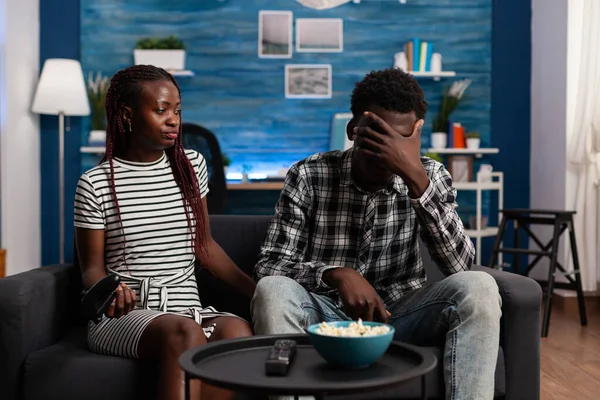 Разочарованная чёрная пара проигрывает в видеоигре по телевизору — стоковое фото