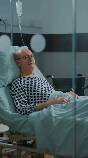 Patiënt met ziekte slapend in ziekenhuisafdeling bed in faciliteit — Stockfoto