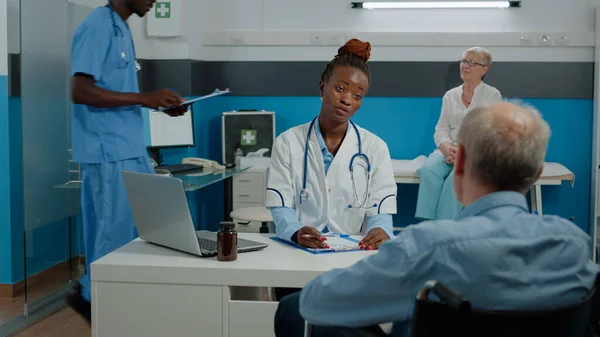 Patient handicapé assis au bureau pour un examen médical — Photo