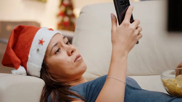 Detailní záběr ženy se Santa klobouk drží smartphone — Stock fotografie