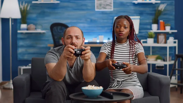 Boyfriend and girlfriend playing video games with controller on console  Stock Photo by ©DragosCondreaW 564191710