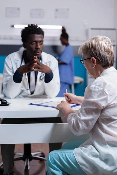 Docteur en ethnicité africaine consultant un patient âgé — Photo