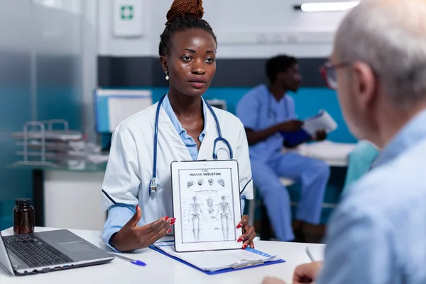 Médecin afro-américain tenant illustration sur écran tablette — Photo