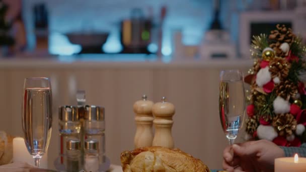 Primer plano de pareja en la cena festiva tintineo copas de champán — Vídeo de stock