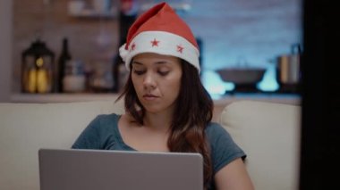 Dizüstü bilgisayarla çalışan ve televizyon izleyen şenlikli kişi.