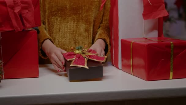 Primer plano de las manos sosteniendo la caja actual con cinta y pajarita — Vídeos de Stock