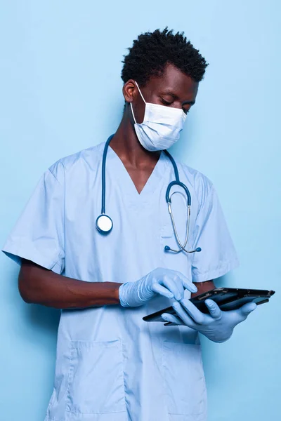 Man working as nurse holding digital tablet in studio — Stock Photo, Image