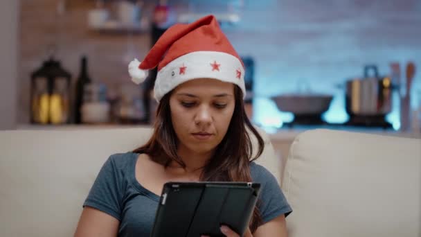 Personne portant le chapeau de Père Noël et travaillant sur la tablette numérique — Video