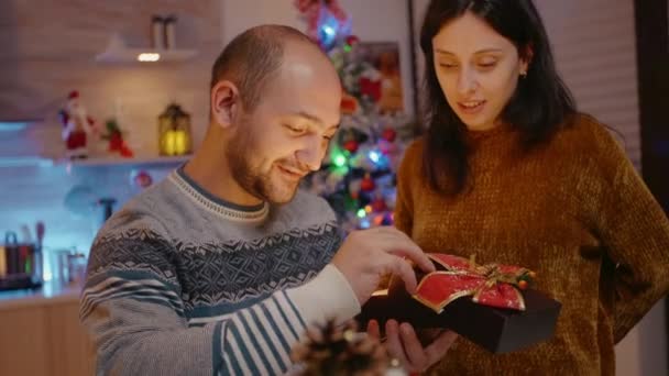 Festlig kvinna ger presentförpackning till man firar julafton — Stockvideo
