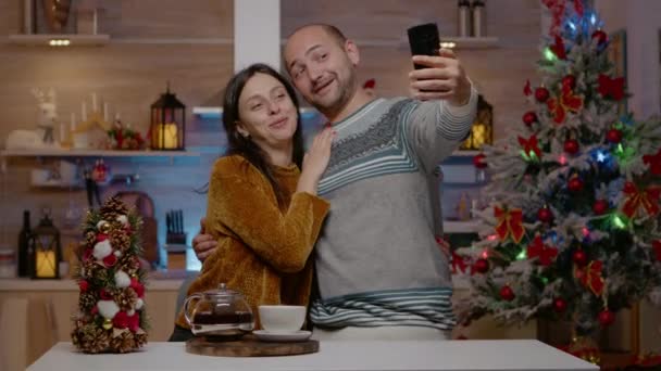 Cheerful couple taking pictures on christmas eve — Stock Video
