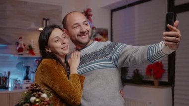 Neşeli bir çift telefonuyla fotoğraf çekiyor. Neşeli hissediyorlar.