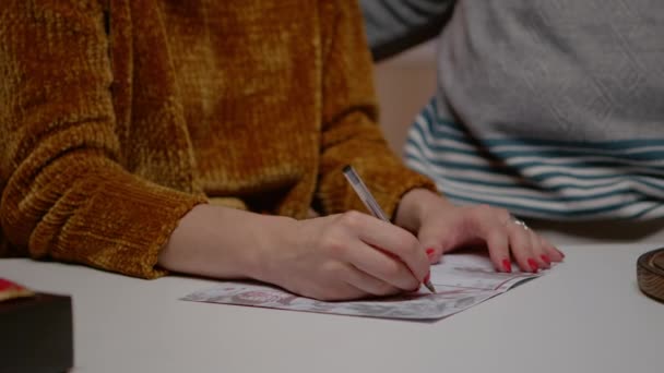 Primer plano de la mujer sosteniendo la pluma y la firma de la tarjeta de Navidad — Vídeos de Stock