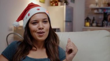 Gülen ve Noel Baba şapkası takan bir kadın.