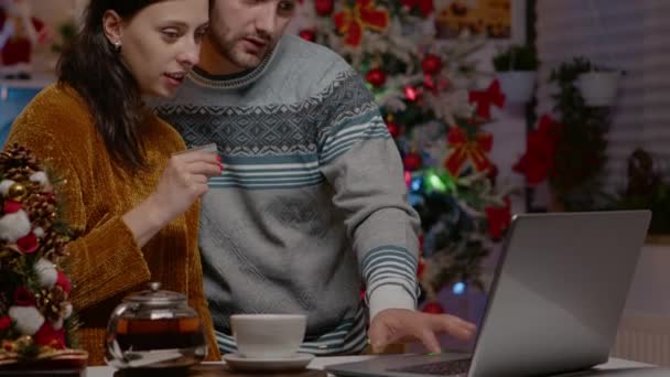 Casal usando laptop e cartão de crédito para compras de Natal — Vídeo de Stock