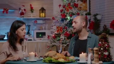 Noel yemeğinde hediye veren ve alan neşeli bir çift.