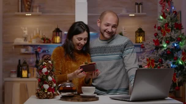 Alegre pareja recibiendo regalos en videollamada para Navidad — Vídeos de Stock