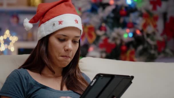 Zbliżenie kobiety z kapeluszem Mikołaja trzymającej tablet cyfrowy — Wideo stockowe