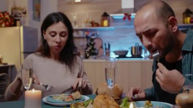 Kadın ve erkek tavuk yer ve kadehleri şampanyayla tokuşturur.