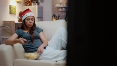 Mutsuz kişi kanal değiştirmek için TV uzaktan kumandası kullanıyor