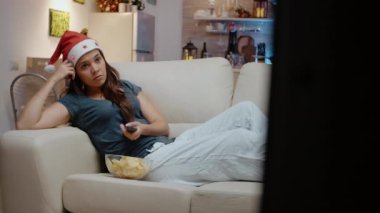 Sıkıcı yetişkin elinde uzaktan kumandayla kanal değiştiriyor