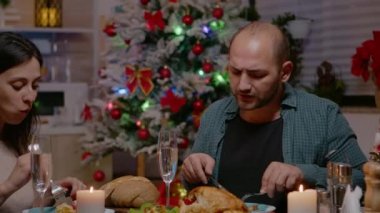 Mutlu çift Noel yemeğinin ve kadeh tokuşturmanın tadını çıkarıyor.