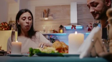 Noel arifesinde şenlikli yemek yiyen çiftin yakın çekimi.