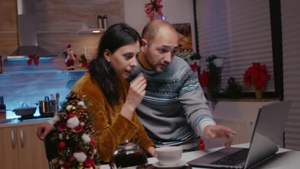 Праздничная пара, использующая кредитную карту для покупки рождественских подарков — стоковое видео
