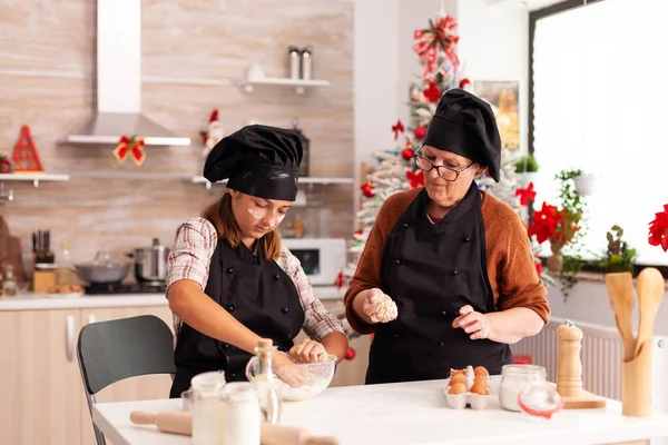 Nieto preparando masa casera con la abuela celebrando la temporada de Navidad —  Fotos de Stock