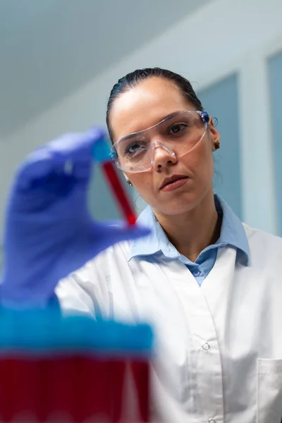 Bióloga investigadora mujer sosteniendo vacutainer de sangre analizando durante experimento científico —  Fotos de Stock