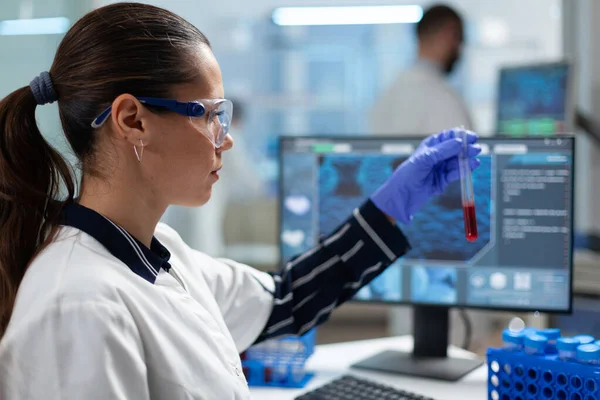 Investigador biólogo sosteniendo tubo de análisis de sangre analizando ADN experiencia médica —  Fotos de Stock