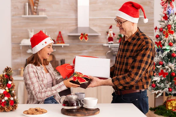 Avô surpreendente neta com presente embrulho xmas — Fotografia de Stock