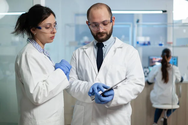 Mujer científica analizando la experiencia del virus con la investigadora bióloga — Foto de Stock