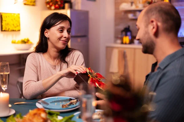 Glückliches Paar genießt Weihnachtsurlaub und überrascht mit Weihnachtsgeschenk mit Schleife — Stockfoto